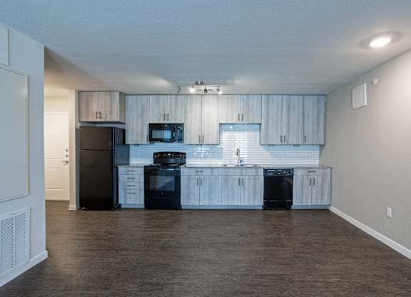 A kitchen with black appliances and white cabinets.