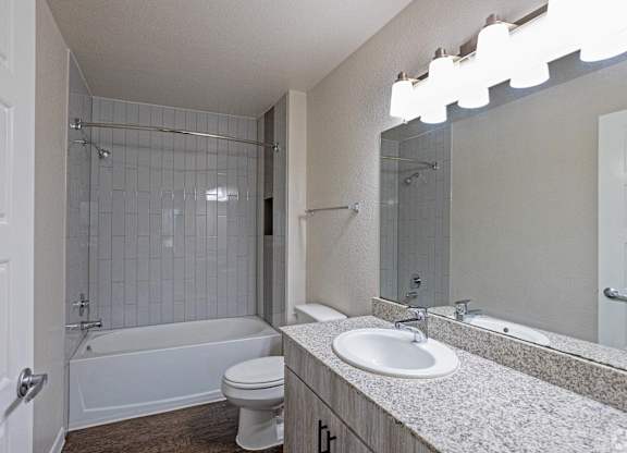 A white bathroom with a toilet, sink, and bathtub.