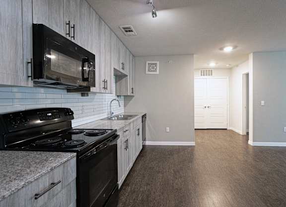 A kitchen with a black microwave above the stove.