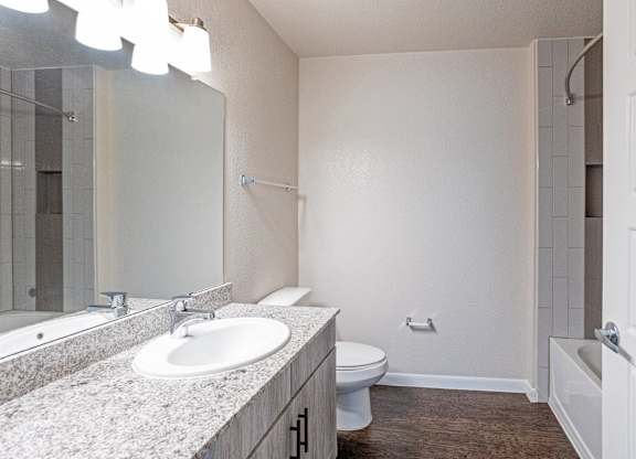 A bathroom with a sink, toilet, and bathtub.