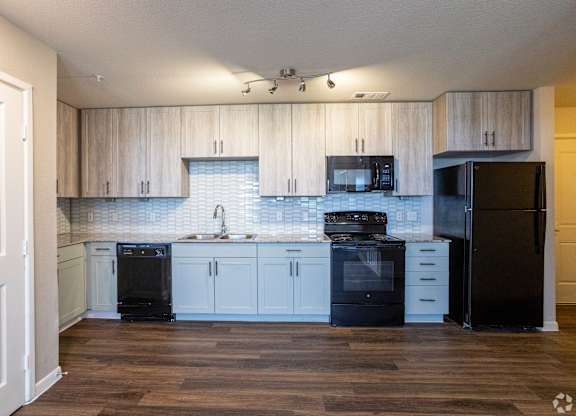 A kitchen with black appliances and wooden cabinets.