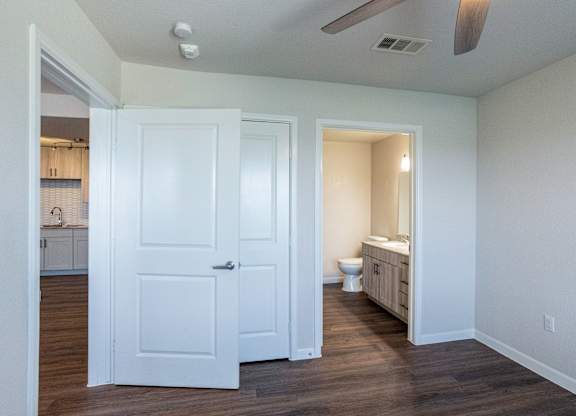 A white door is open to a bathroom with a toilet and sink.