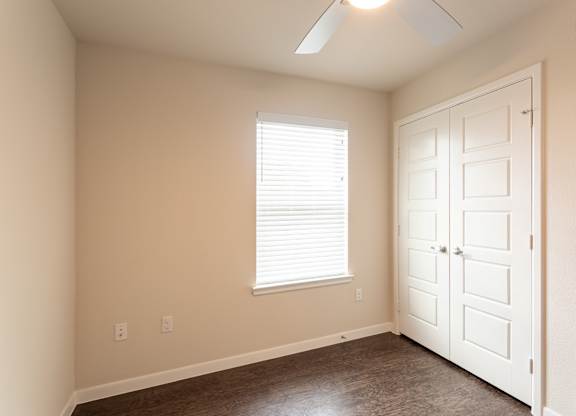 A room with a white door and a window with blinds.