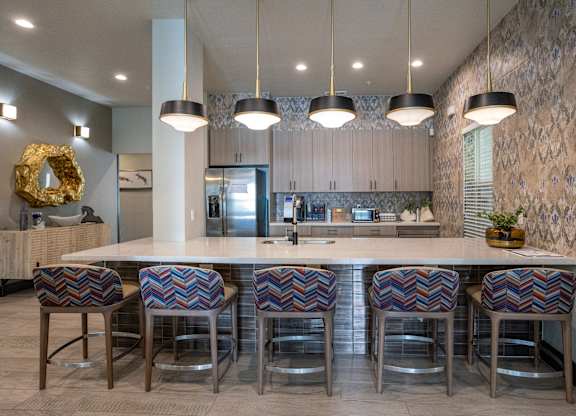 A kitchen with a white counter top and bar stools.