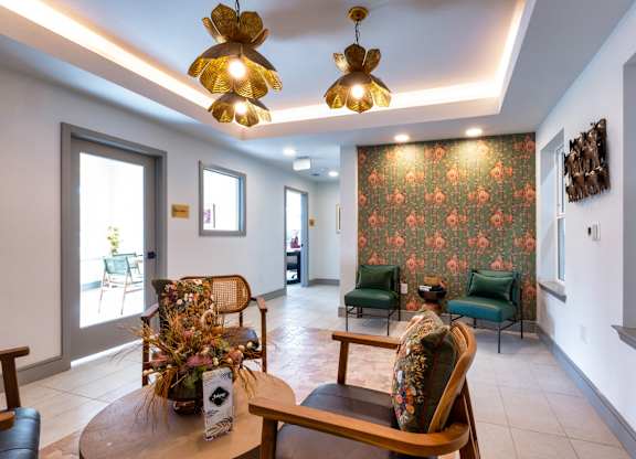 A living room with a floral wallpaper and a wooden table.