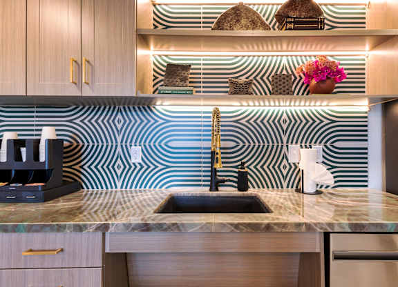 A kitchen with a sink and a coffee maker.
