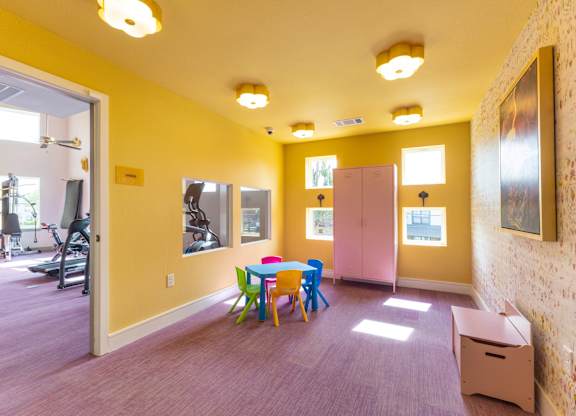 A room with a yellow wall and a purple carpet.