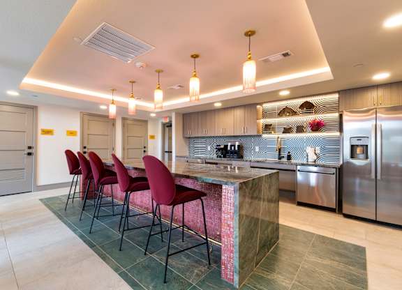A kitchen with a bar area and chairs.