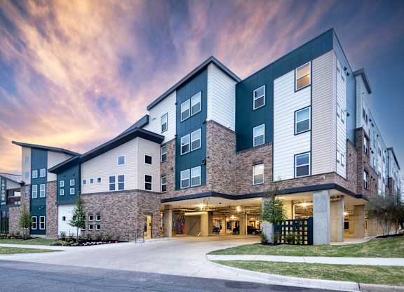 A modern apartment building with a mix of green and beige exterior colors.
