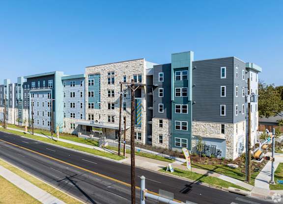 A street view of a row of modern apartment buildings.