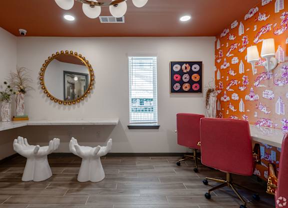 A room with a round mirror, two chairs, and a wall with a patterned design.