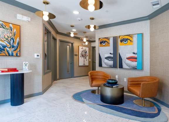A hallway with a blue carpet and a painting of a woman's face on the wall.