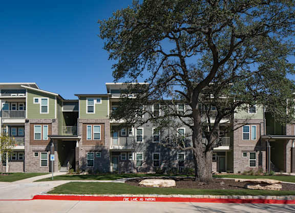 Apartment complex with a tree in front.
