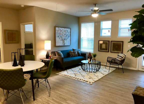 A living room with a green couch, a white table, and a rug.