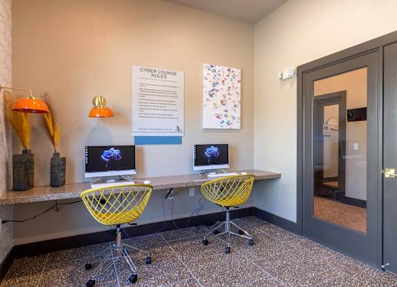 A room with two computers and a sign that says Cyber Lounge Rules.