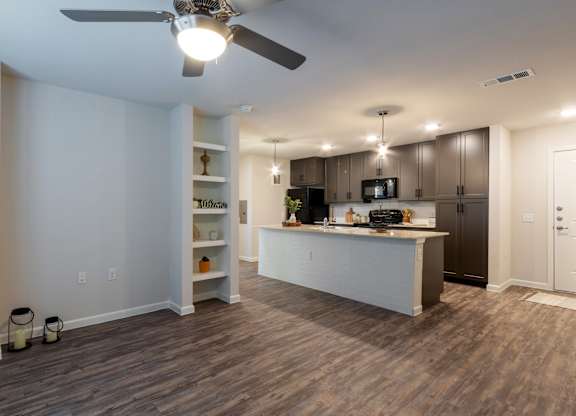 A kitchen with a white island and a ceiling fan.