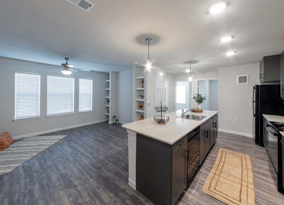 A kitchen with a white island and black appliances.