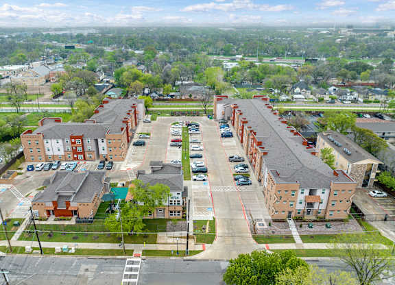 A large parking lot is in front of a long building.