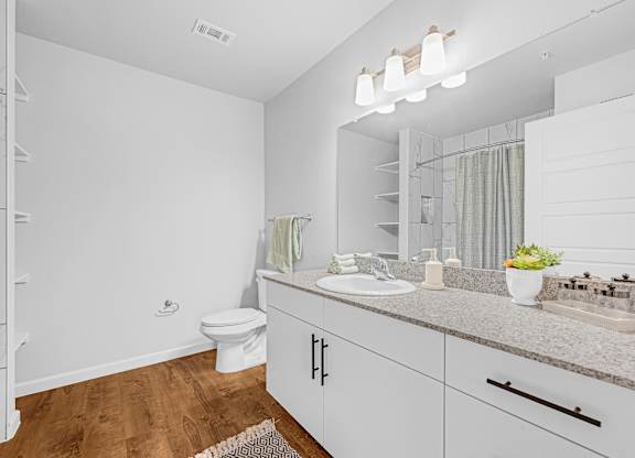 A white bathroom with a toilet, sink, and mirror.