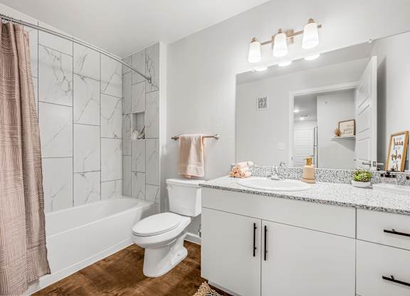 A white toilet sits next to a white sink in a bathroom.
