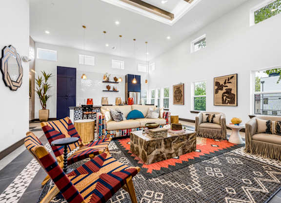 A living room with a variety of furniture including a sofa, armchairs, and a coffee table.