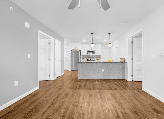 A kitchen with a wooden floor and white walls.