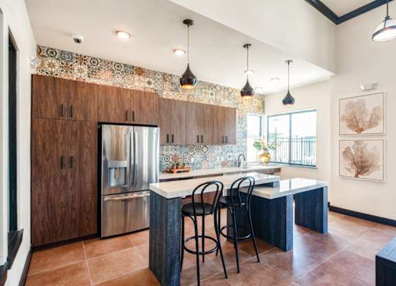 A kitchen with a tile backsplash and a large island.