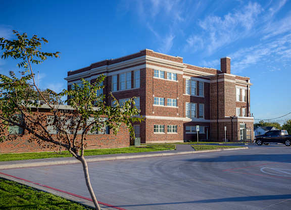A red brick building with a tree in front of it.