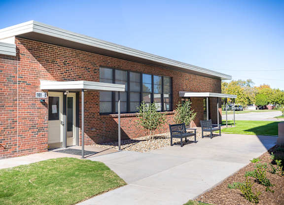 A brick building with a white awning and a sign that says "TOL 6-8".