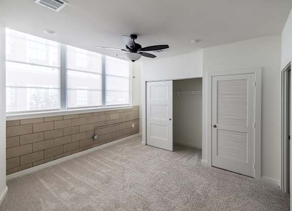 A room with a ceiling fan and a window.