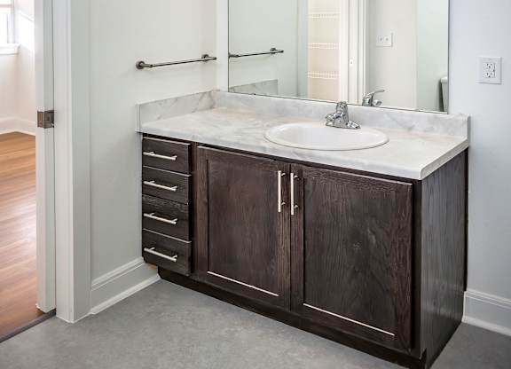 A bathroom with a sink, mirror, and lights.