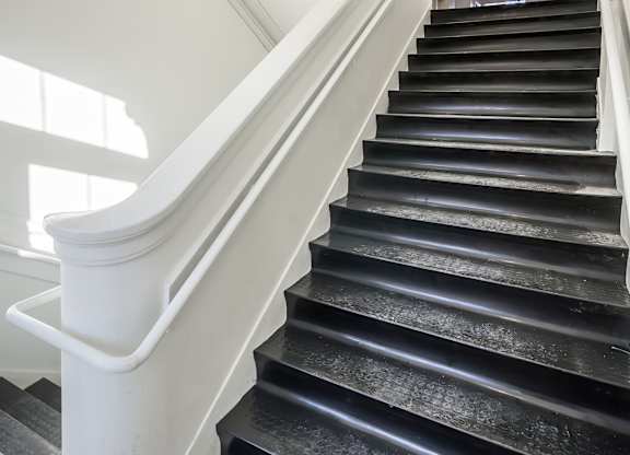 A staircase with black steps and white railings.