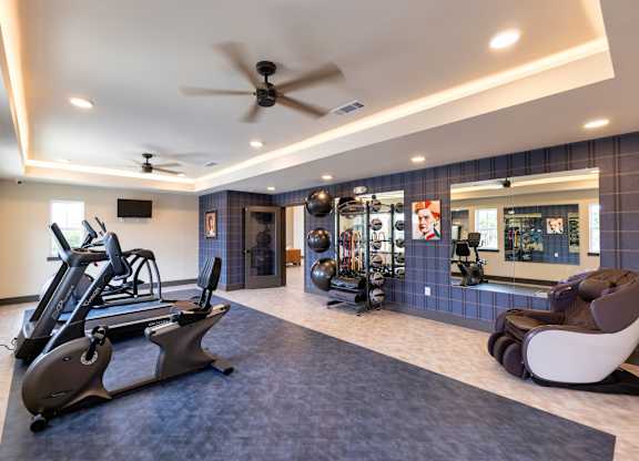 A spacious gym with a treadmill, exercise balls, and a mirror.