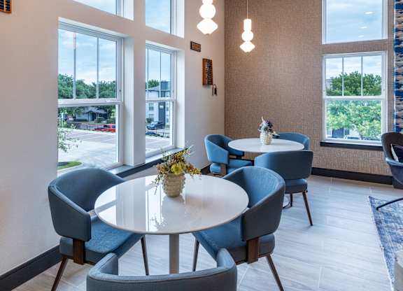 A room with a table and chairs with a view of the outside.
