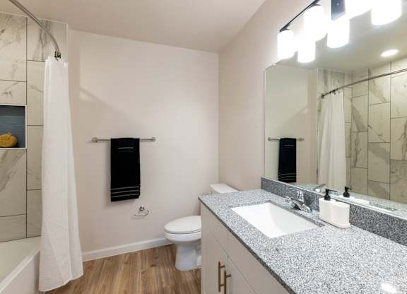 A bathroom with a toilet, sink, and shower.