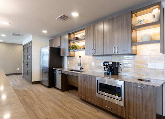 A modern kitchen with wooden cabinets and stainless steel appliances.