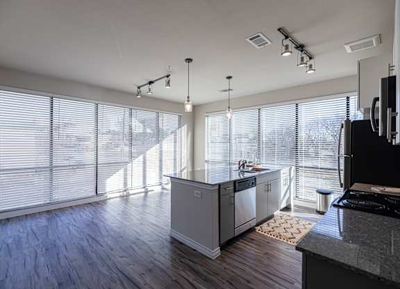 A modern kitchen with wooden floors and white walls.
