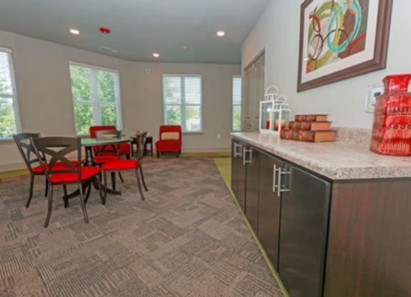 A kitchen with a table and chairs in front of a window.