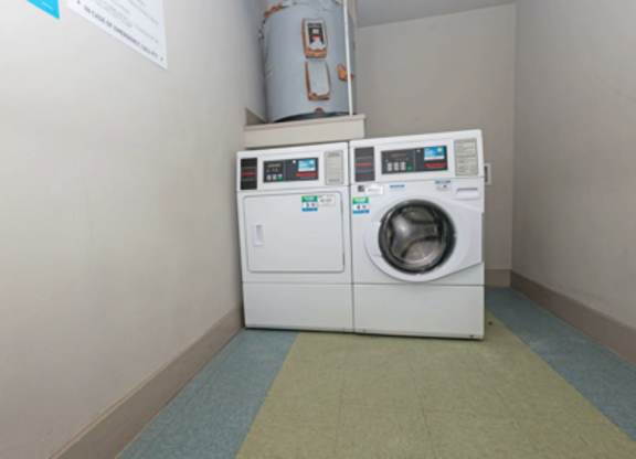 A white washing machine and dryer in a small room.