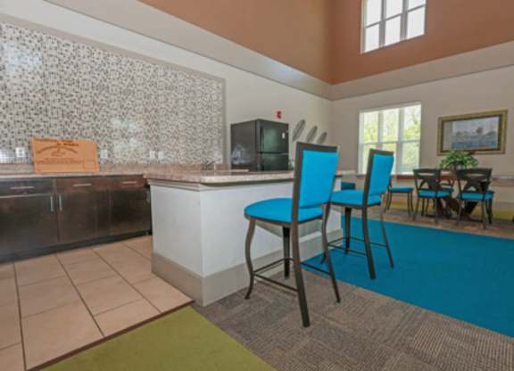 A kitchen with a blue chair and a blue rug.