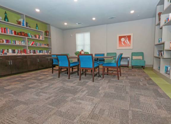 A room with a carpeted floor and a bookshelf filled with books.