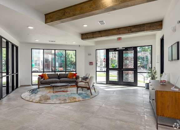 A spacious living room with a couch, coffee table, and a rug.