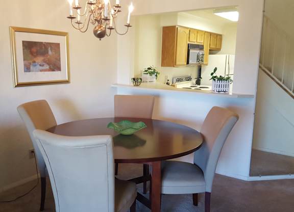 A dining room with a table and chairs.