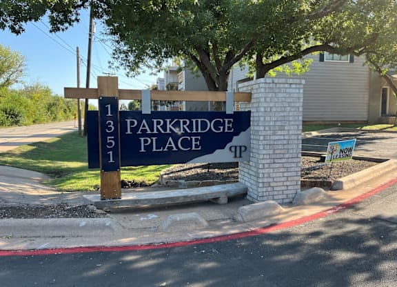 A sign for Parkridge Place is displayed in front of a building.