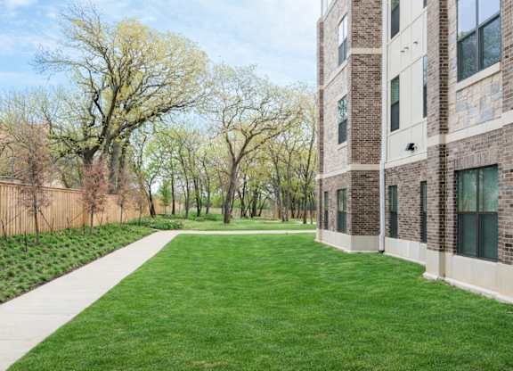 A grassy area in front of a brick building.