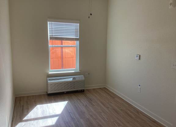 A room with a window and a heater.