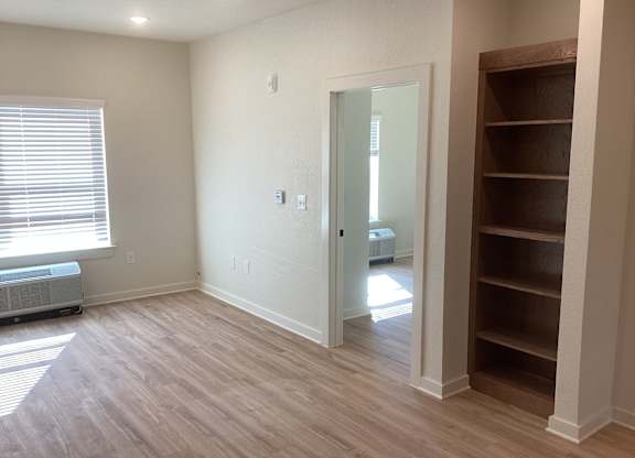 A room with a white door and a window with blinds.