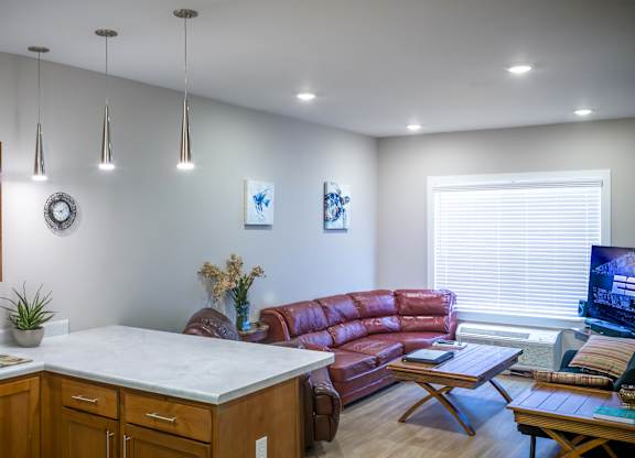 A living room with a red couch and a white counter.