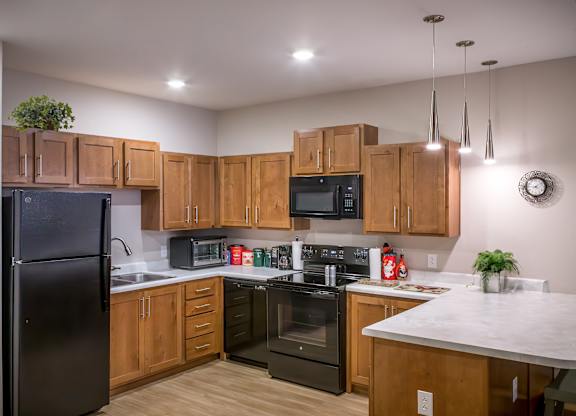 A kitchen with wooden cabinets and black appliances.