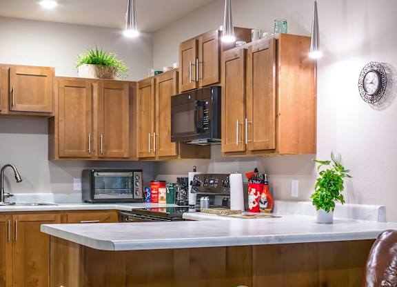 A kitchen with a bar stool and a chair.